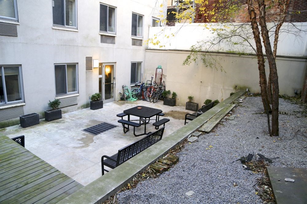 a courtyard with a table and benches in front of a building