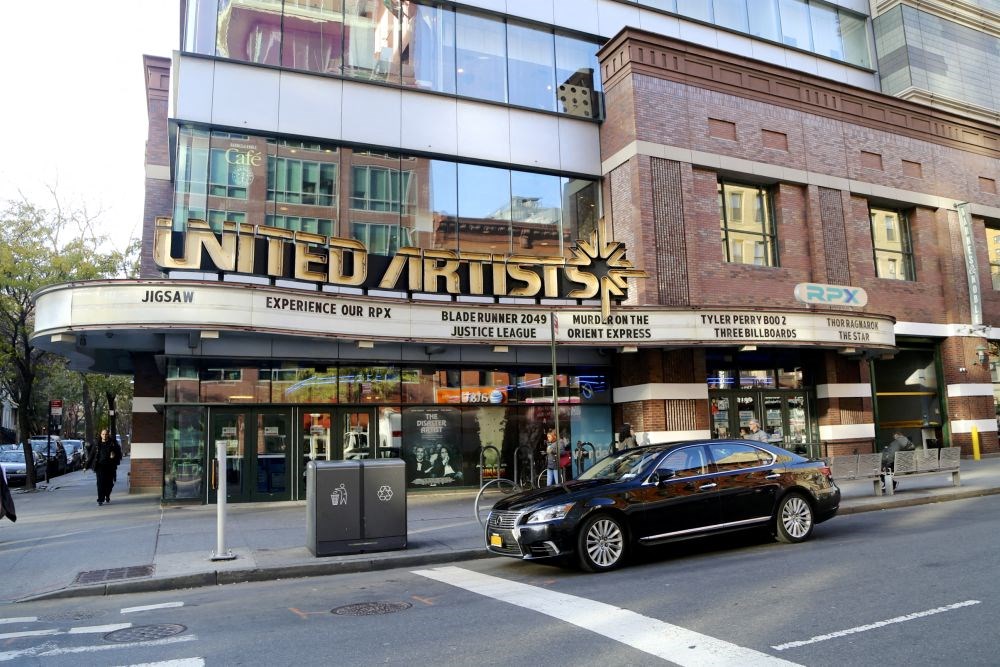 a car parked in front of a united kingdom theater on a city street