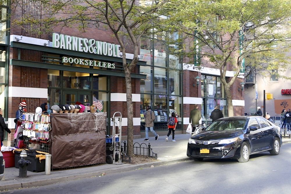 a car parked in front of a bookstore on a city street