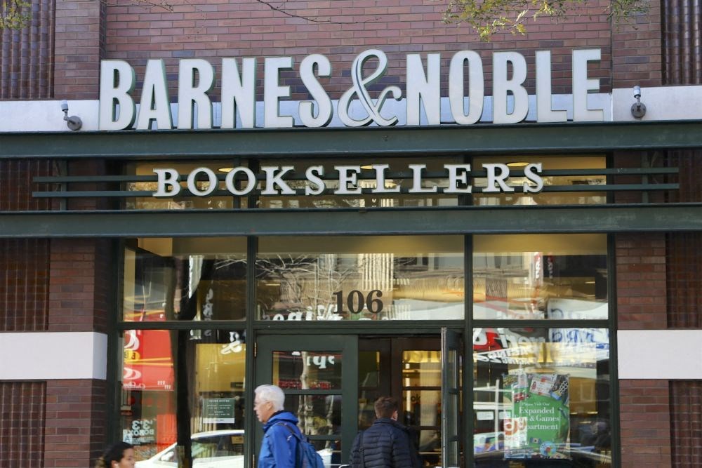 the front of a bookstore with people walking in front of it