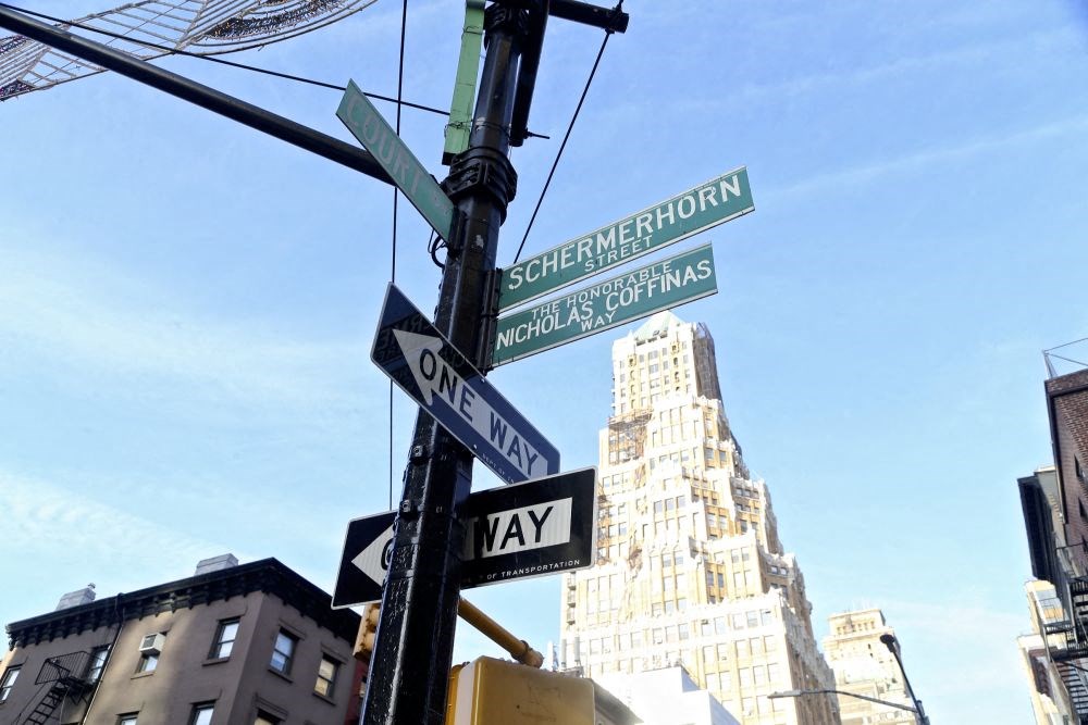 a street pole with many street signs on it