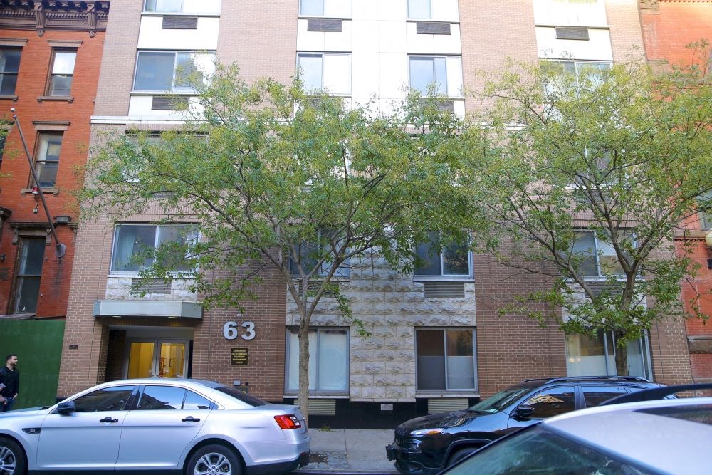 an apartment building with cars parked in front of it