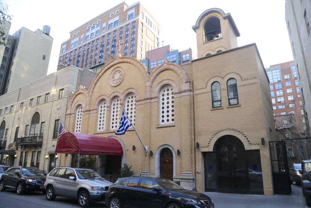 a church with a clock tower on the side of a street