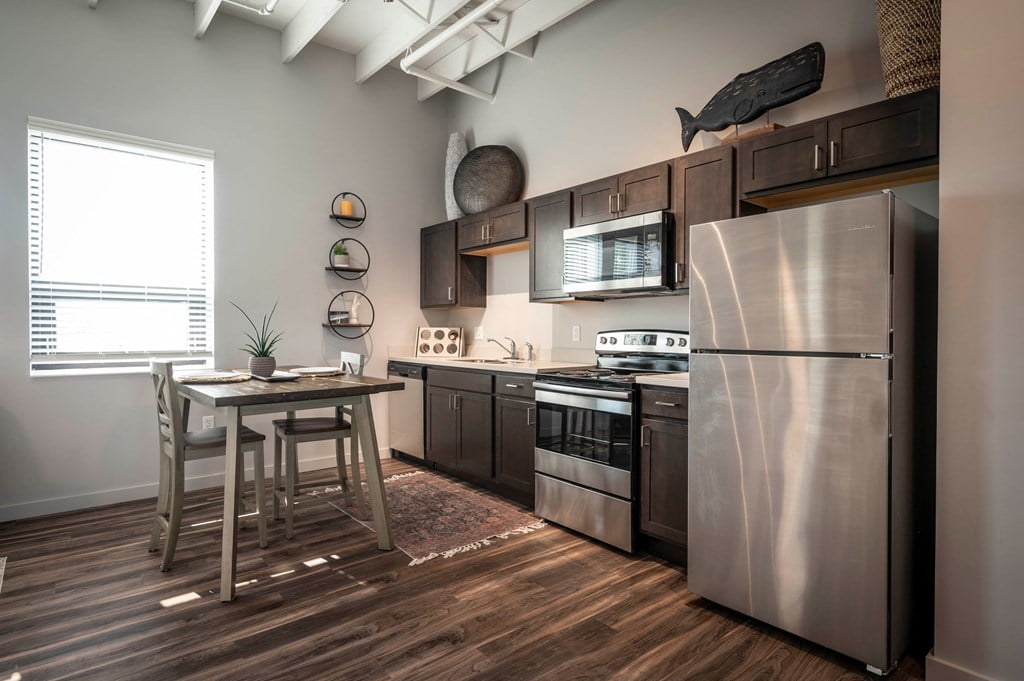 a kitchen with stainless steel appliances and a wooden table