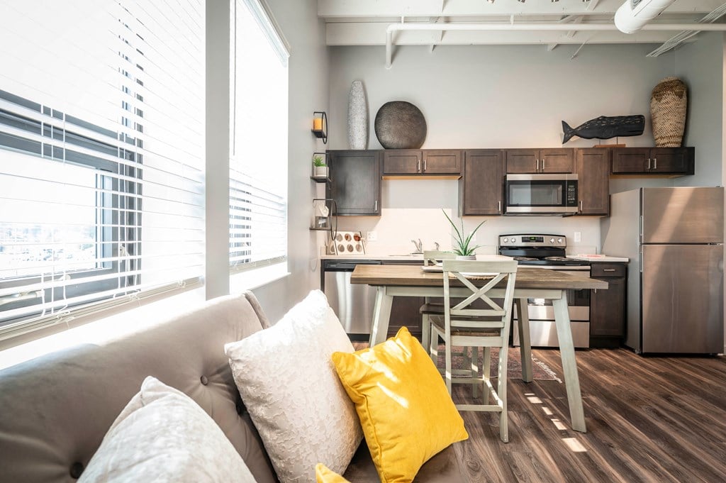 a living room with a couch and a kitchen with a table