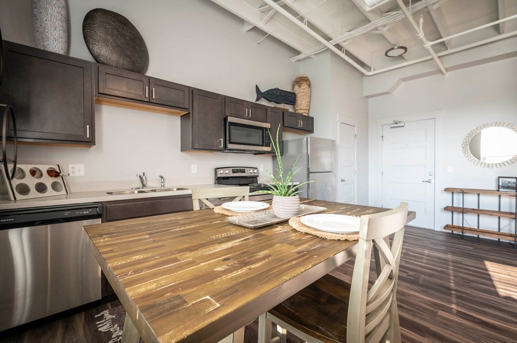 a kitchen with stainless steel appliances and a wooden table