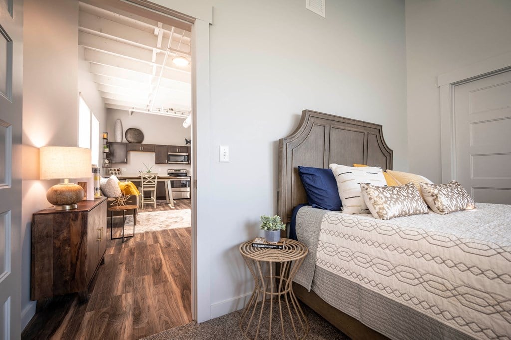 a bedroom with a bed and a living room with a kitchen