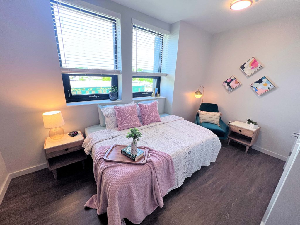 a bedroom with a bed and two windows