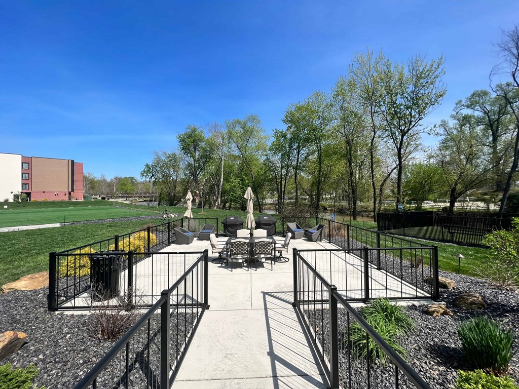 a patio with benches and tables in a park