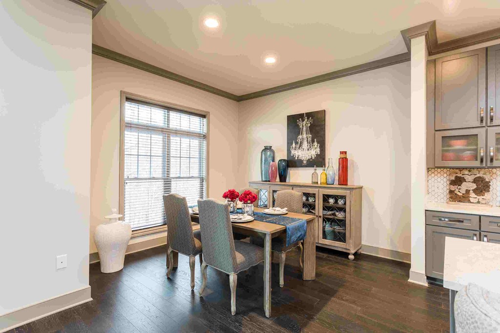 a dining room with a table and chairs and a window