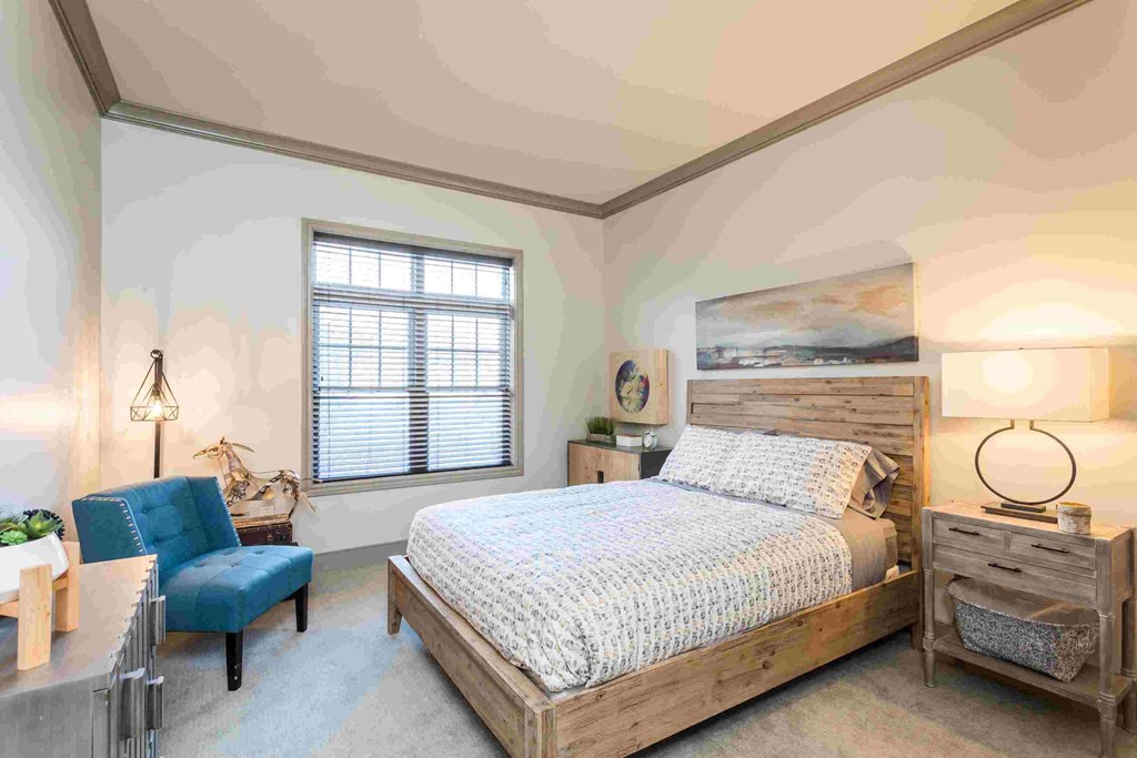 a bedroom with a bed and a chair and a desk