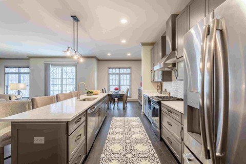 a large kitchen with stainless steel appliances and white counter tops