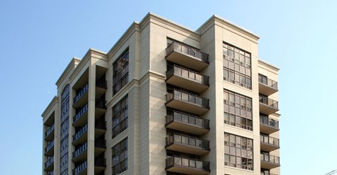 a tall building with balconies and a blue sky