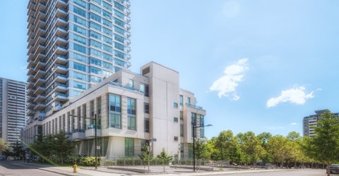 A modern building with a glass facade stands tall in the city.