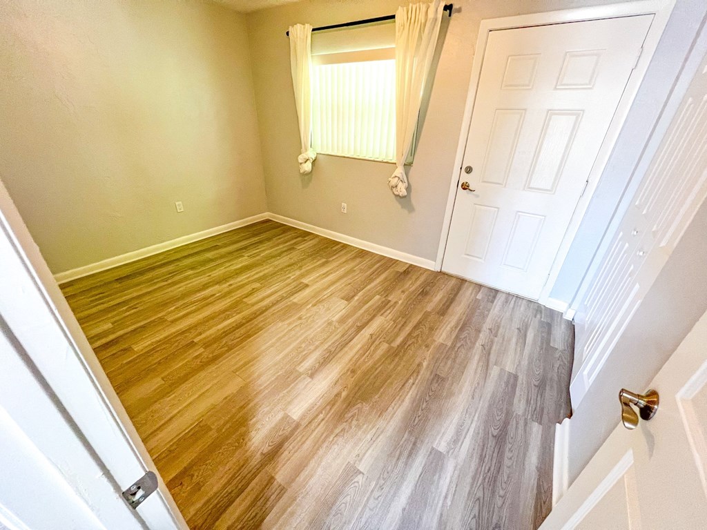 an empty room with wood flooring in a home