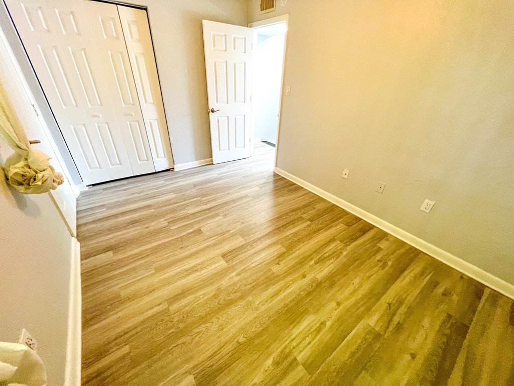 the living room and dining room of an empty home with wood flooring