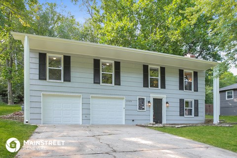 a blue house with a driveway and a blue garage door
