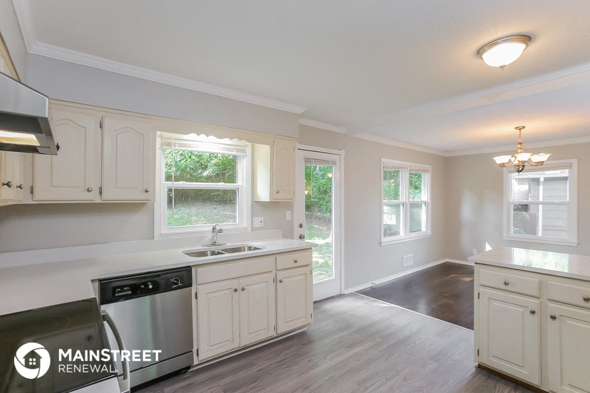 the kitchen of a home with white cabinets and a black dishwasher