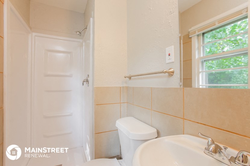 a bathroom with a toilet and a sink and a window