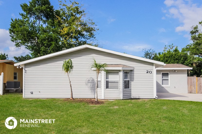 a small white house with palm trees in front of it