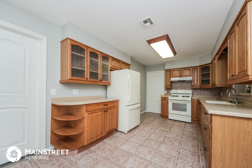 a kitchen with wooden cabinets and white appliances and a white refrigerator