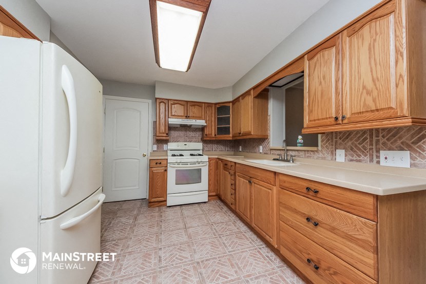 a kitchen with wooden cabinets and white appliances and a white refrigerator