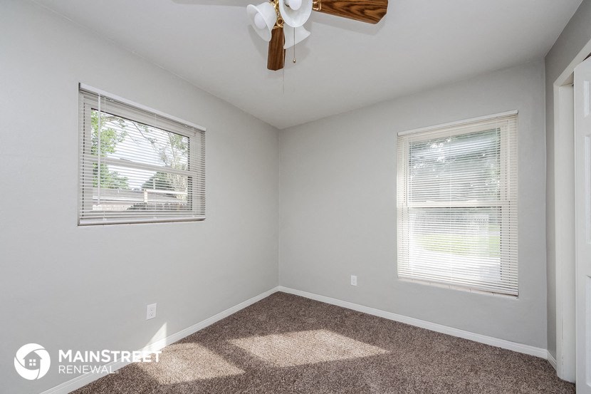 the master bedroom has carpeted floors and a ceiling fan