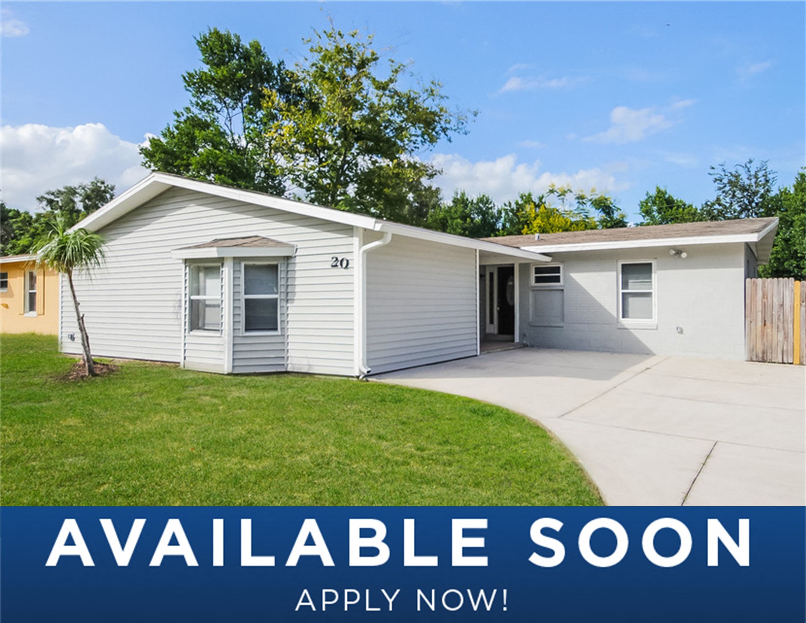 a small white house with a lawn and a driveway
