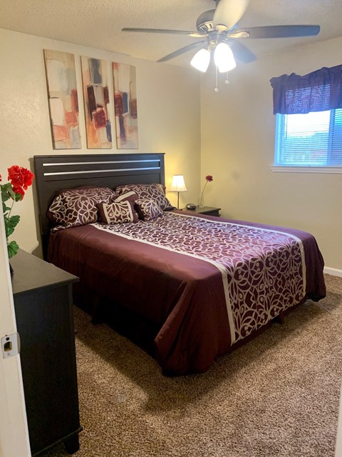 a bedroom with a bed and a ceiling fan