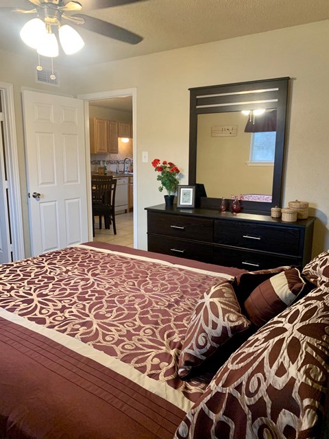 a bedroom with a bed and a dresser with a mirror