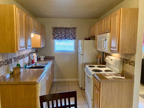 a kitchen with white appliances and wooden cabinets