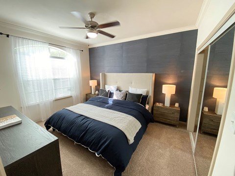 a bedroom with a bed and a ceiling fan