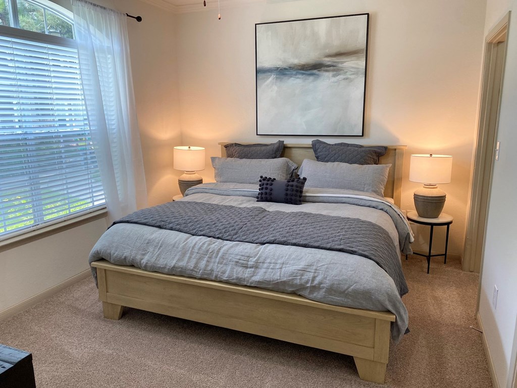 a bedroom with a bed and a large window