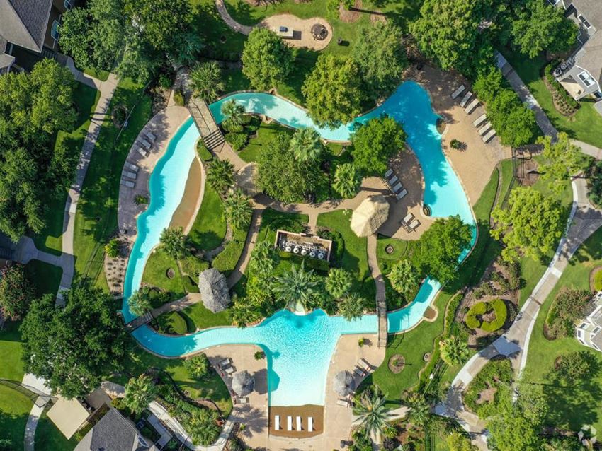 a resort with a swimming pool and a hotel with trees