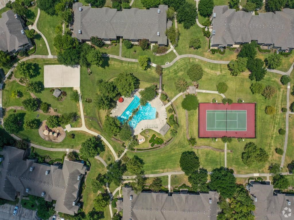 arial view of a house with a tennis court and a pool