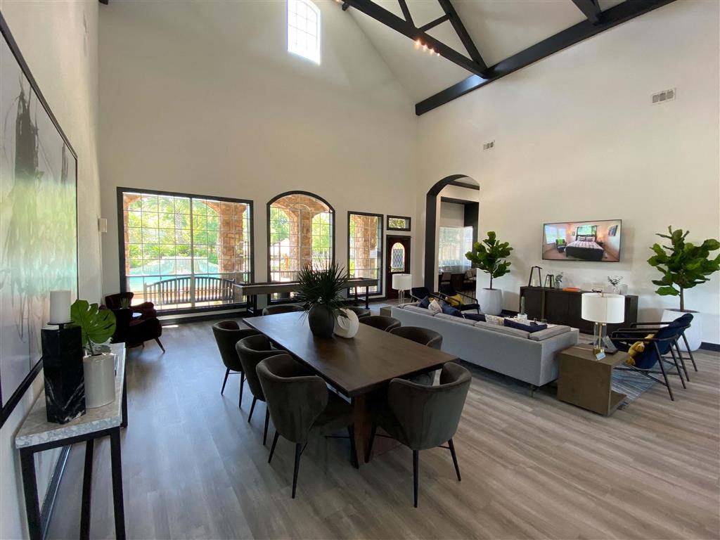 a large living room with a wooden floor and a table and chairs