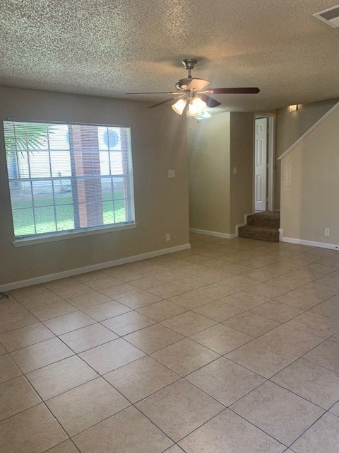 an empty living room with a ceiling fan