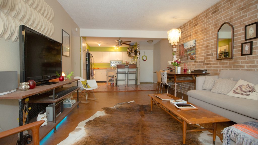 a living room with a brick wall and a television