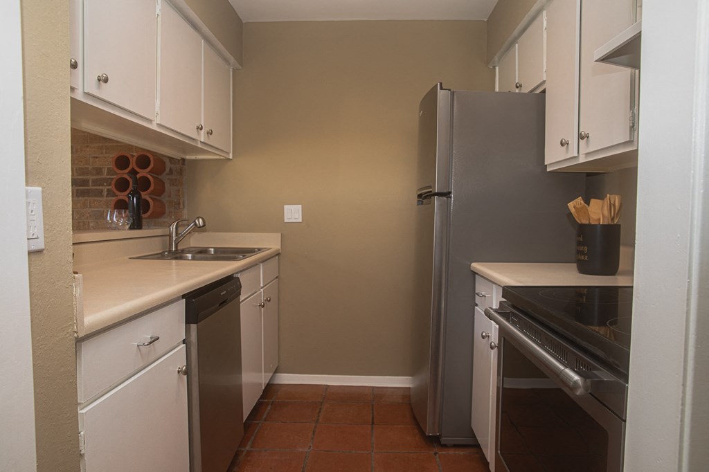 a kitchen with white cabinets and a stainless steel refrigerator