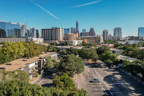 an aerial view of an empty parking lot with the city skyline in the background