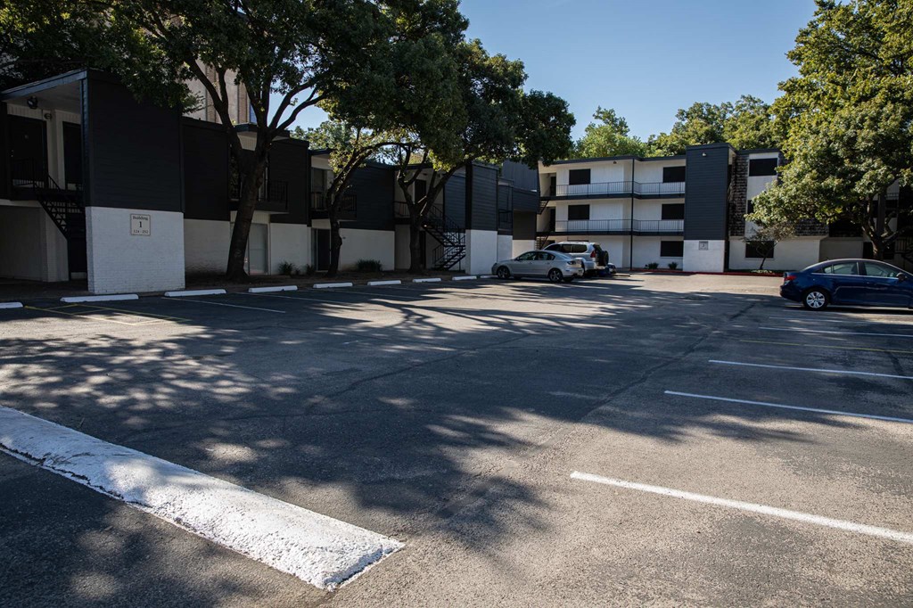 an empty parking lot in front of an apartment building