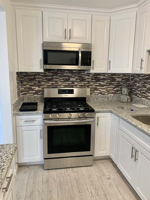 A kitchen with a stove top oven and microwave above it.