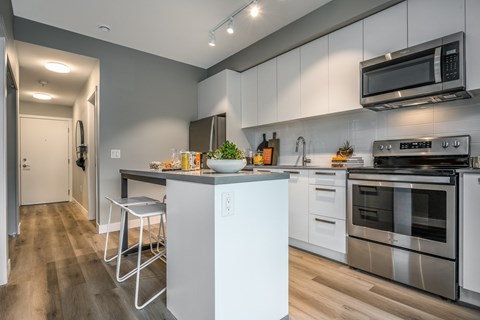 a kitchen with stainless steel appliances and a counter with stools