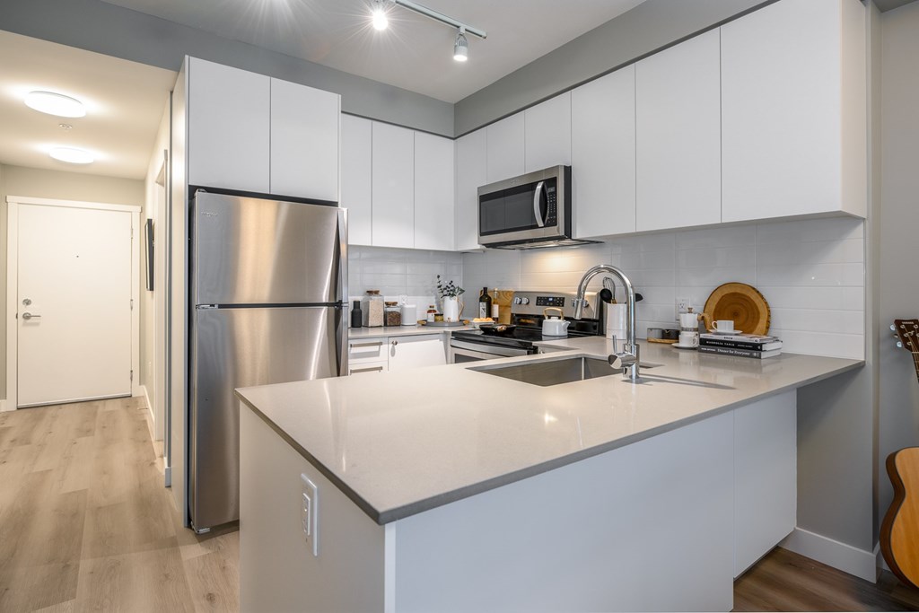 a kitchen with an island and a stainless steel refrigerator