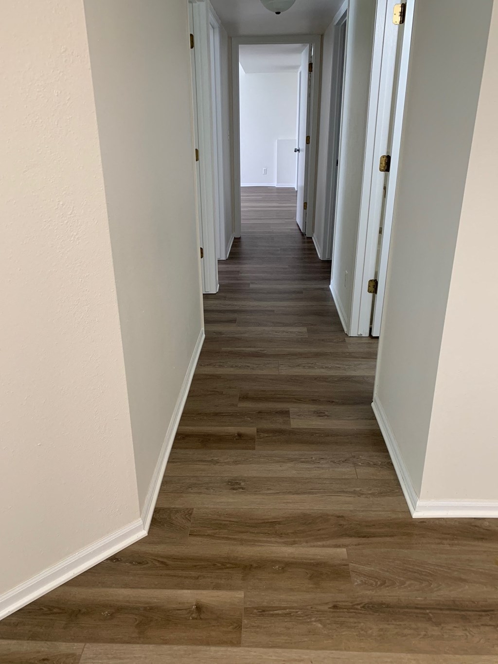 a hallway with wood floors and white walls
