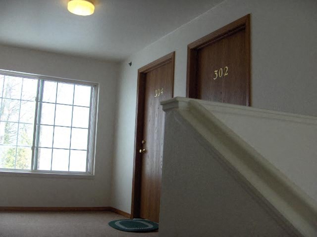 an empty room with a staircase and a door and a window