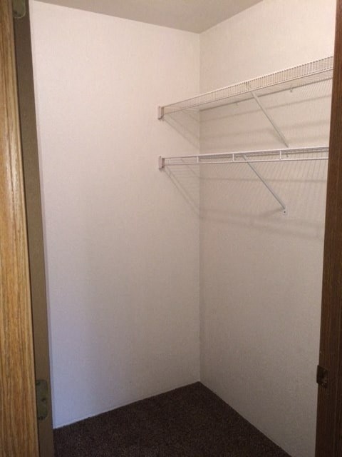 a walk in closet with a white wall and a white