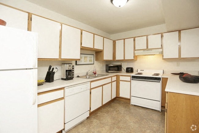 a large kitchen with white appliances and white cabinets