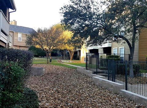 a yard with a fence in front of houses
