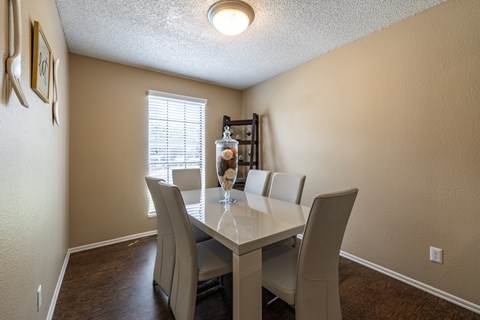A dining room with a table and chairs.